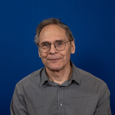 A white man with short brownish/gray hair and glasses