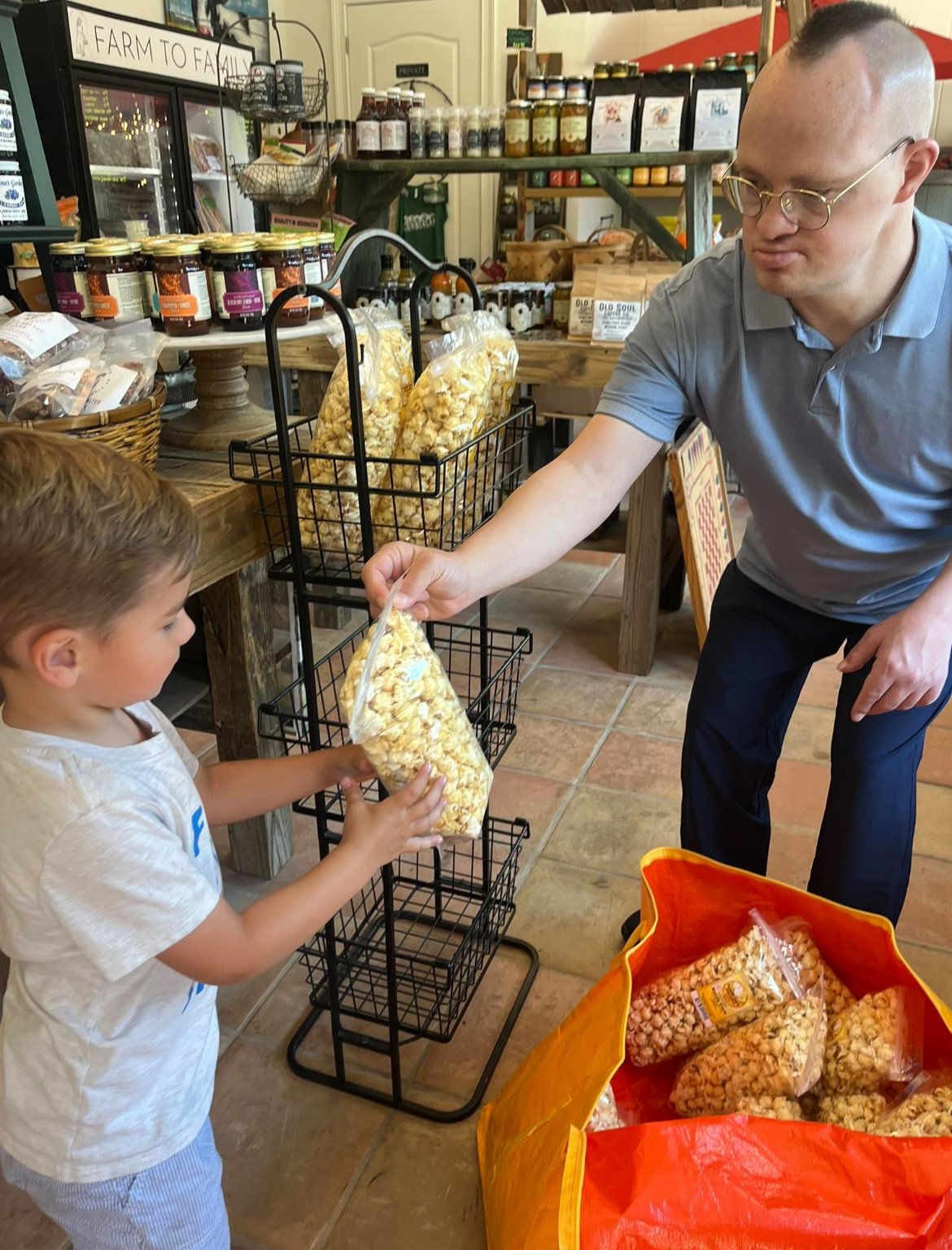 joe handing a bag of popcorn to a child